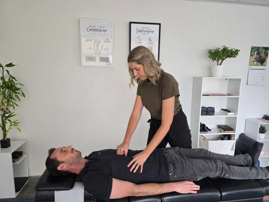 Chiropractor in Auckland conducting a spinal and posture assessment during a first chiropractic visit at Ignite Chiropractic, North Shore